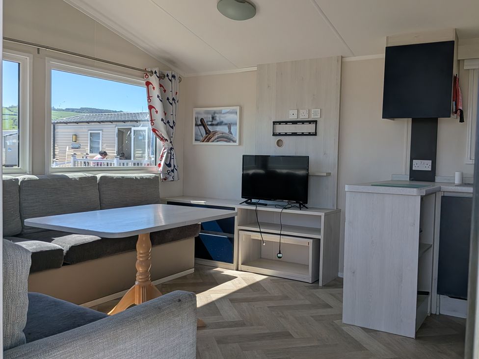 A living room with a sofa and television at Presthaven - Denbigh Dunes Prestatyn