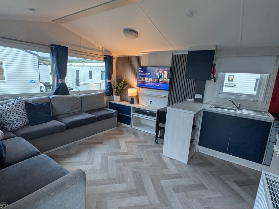 A living room with a sofa and television at Presthaven - Denbigh Dunes, Gronant