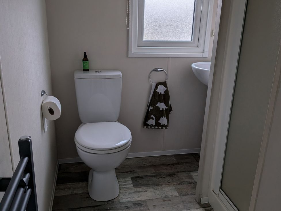 A bathroom with a toilet and sink at Presthaven - Denbigh Dunes in Gronant