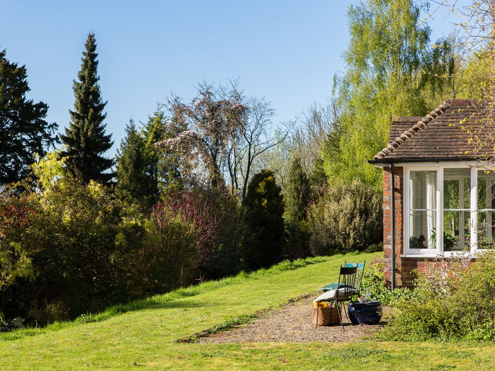 A garden with a chair and pillows at Whitebeams in Pett Bottom near Stelling Minnis