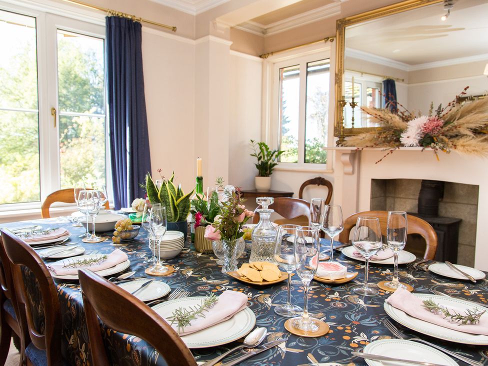 A dining room with a set table and flowers at Whitebeams Pett Bottom near Stelling Minnis