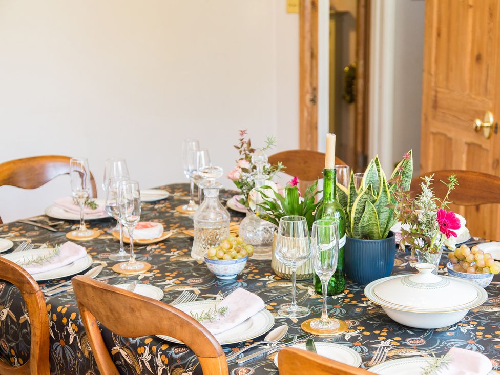 A dining table set with dinnerware and plants at Whitebeams in Pett Bottom near Stelling Minnis
