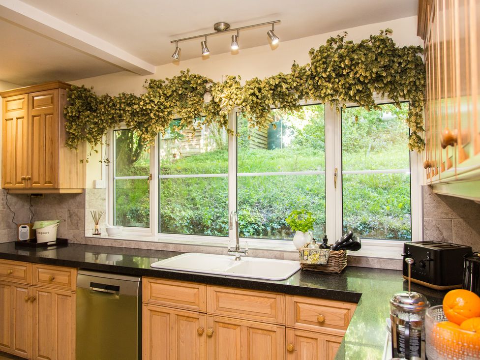 A kitchen with wooden cabinets and a window at Whitebeams, Pett Bottom near Stelling Minnis