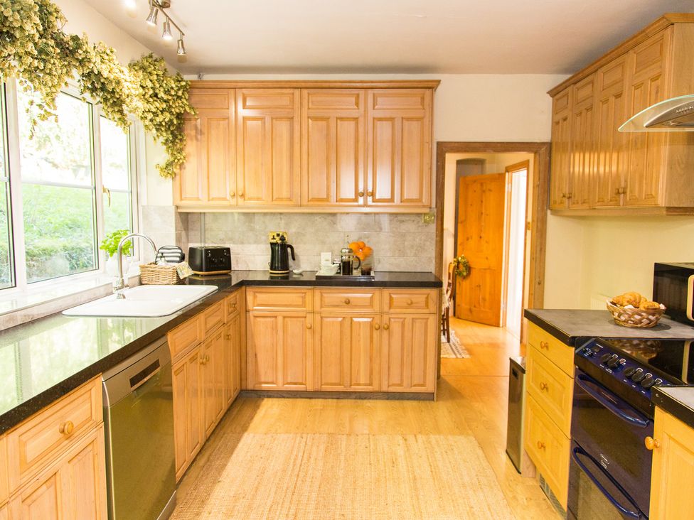 A kitchen with wooden cabinets and appliances at Whitebeams Pett Bottom near Stelling Minnis