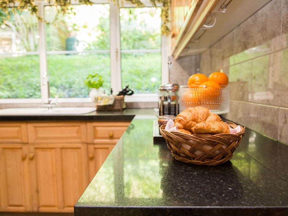 A kitchen with a sink and basket of croissants at Whitebeams in Pett Bottom near Stelling Minnis