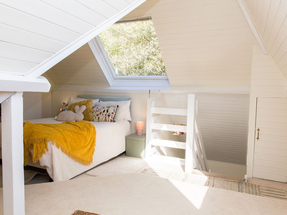 A bedroom with a bed and staircase at Whitebeams in Pett Bottom near Stelling Minnis
