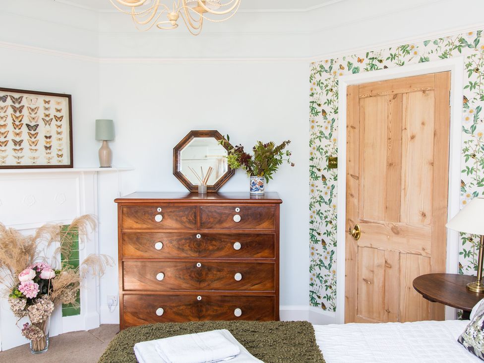 A bedroom with a chest of drawers and a door at Whitebeams Pett Bottom near Stelling Minnis