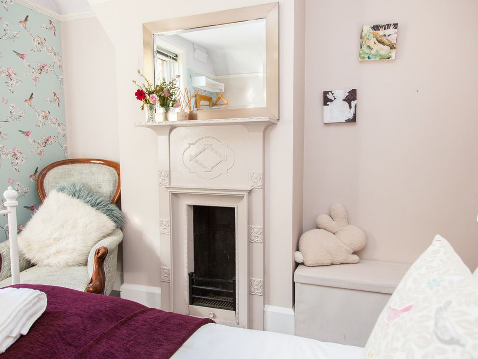 A bedroom with a chair and fireplace at Whitebeams Pett Bottom near Stelling Minnis