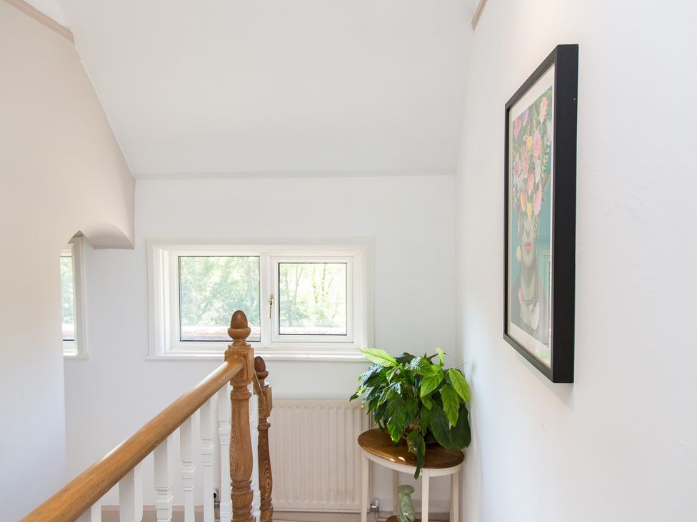 A hallway with a plant and artwork at Whitebeams in Pett Bottom near Stelling Minnis