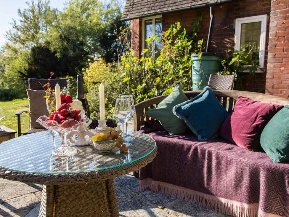 A patio area with a table and strawberries at Whitebeams Pett Bottom near Stelling Minnis