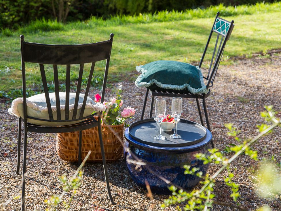 Two chairs with a table and dessert in a garden at Whitebeams Pett Bottom near Stelling Minnis