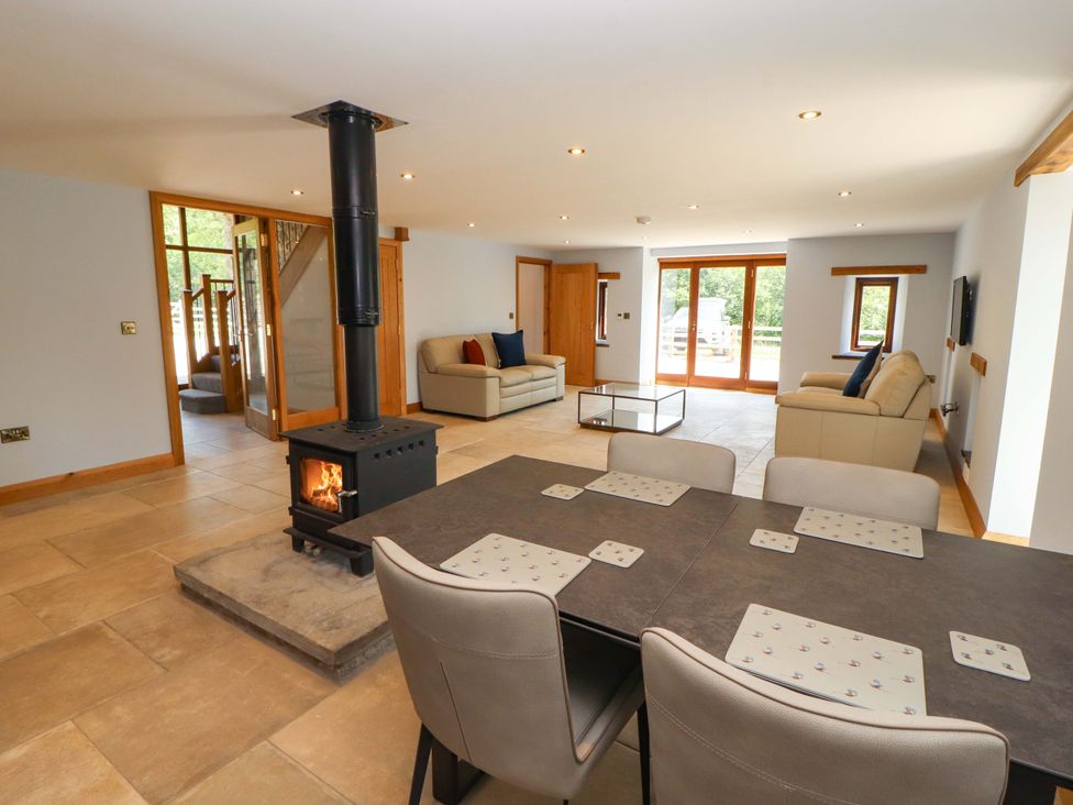 A living room with a dining table and stove at Dam House Barn in Lancaster