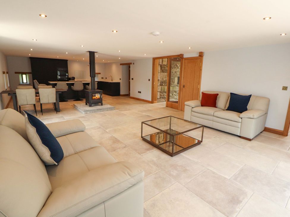 A living room with sofas and a kitchen area at Dam House Barn in Lancaster