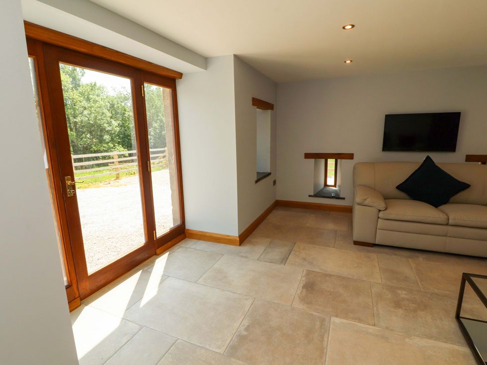 A living room with a sofa and television at Dam House Barn in Lancaster