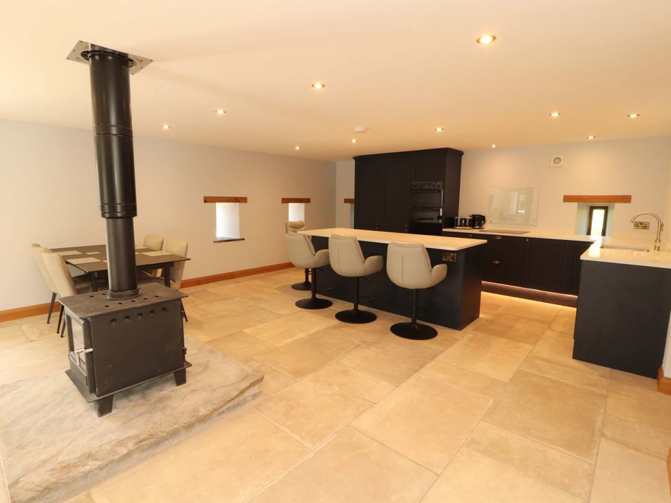 A kitchen with a stove and seating area at Dam House Barn in Lancaster