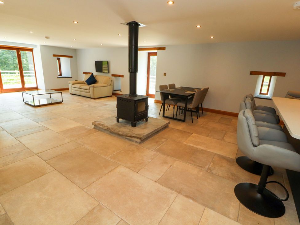 A living room with a wood stove and dining area at Dam House Barn in Lancaster