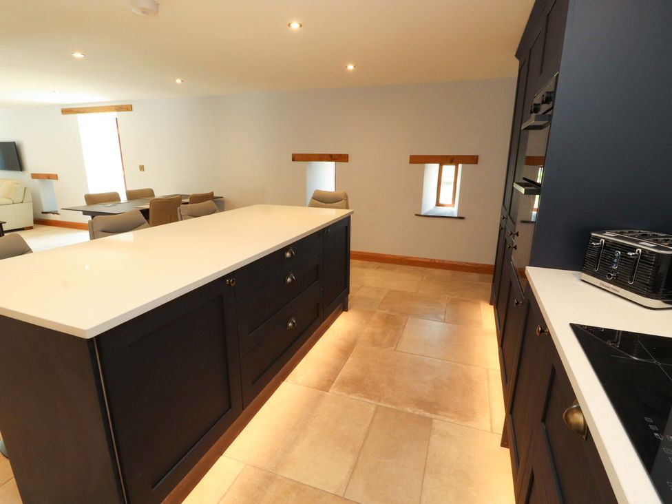 A kitchen with an island and stools at Dam House Barn in Lancaster