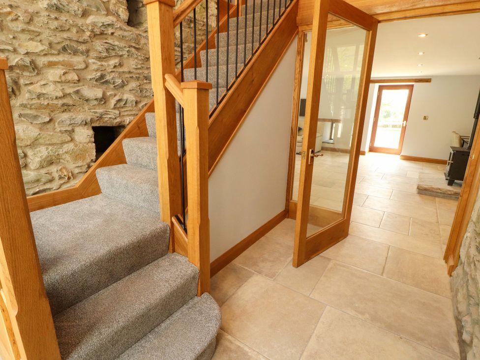 A hallway with stairs and a glass door at Dam House Barn in Lancaster