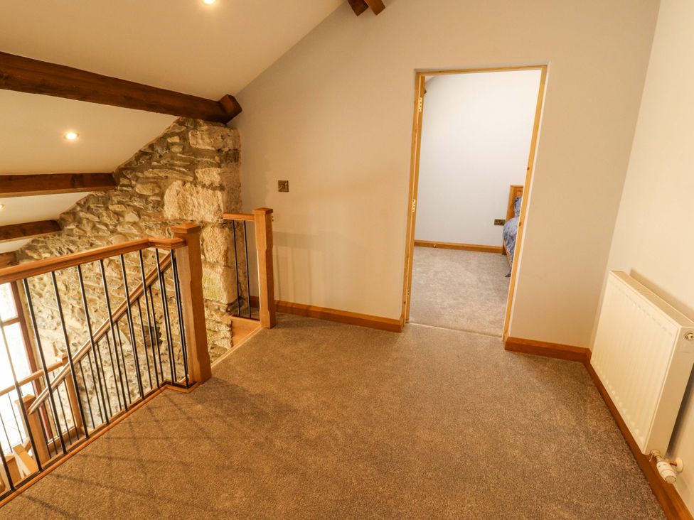 A hallway with a staircase and doorway at Dam House Barn in Lancaster