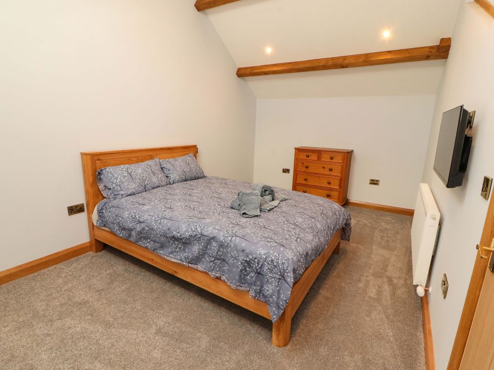 A bedroom with a bed and dresser at Dam House Barn in Lancaster
