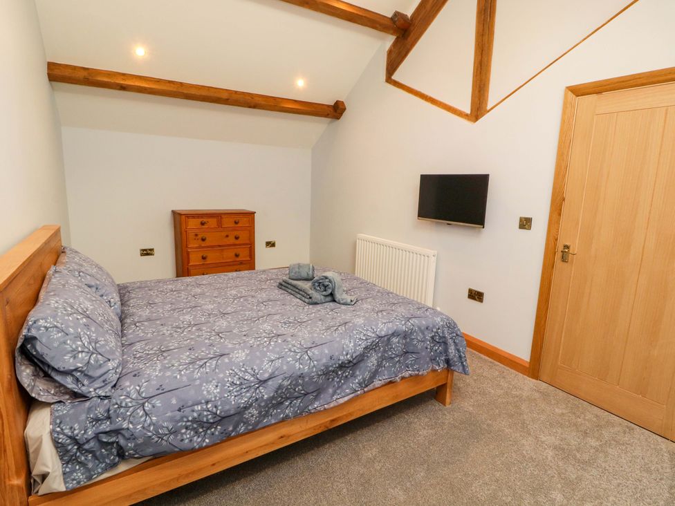 A bedroom featuring a bed with linens and a TV at Dam House Barn in Lancaster