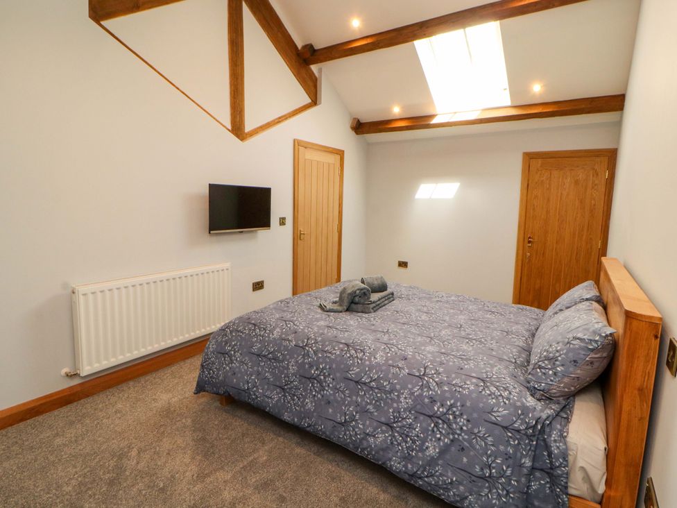 A bedroom with a bed and television at Dam House Barn Lancaster