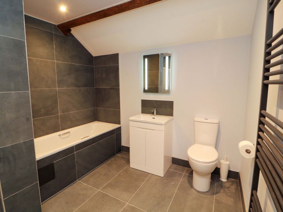 A bathroom with a bathtub, sink and toilet at Dam House Barn in Lancaster