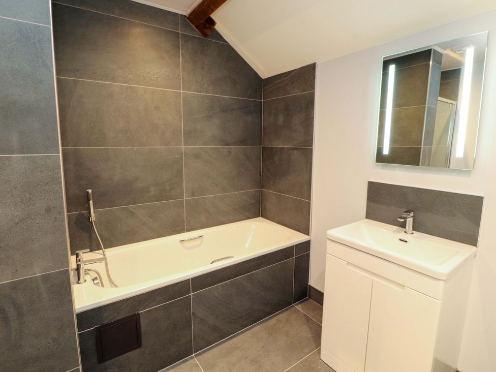 A bathroom with a bathtub and sink at Dam House Barn in Lancaster