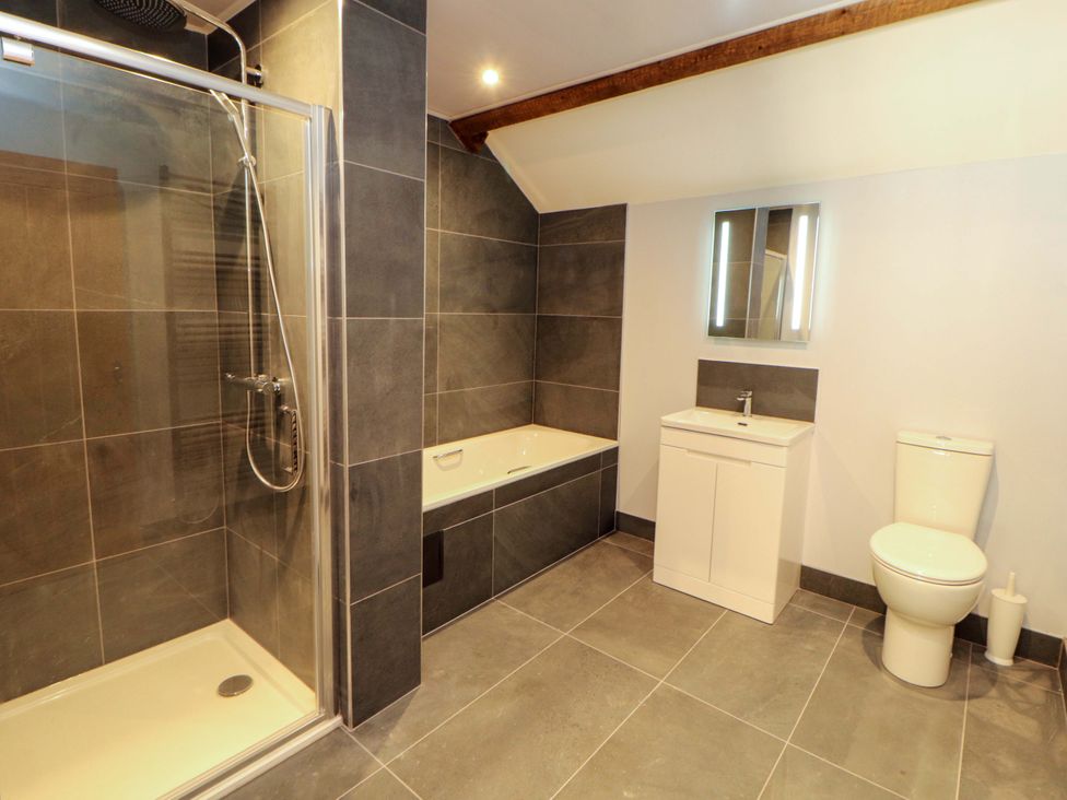 A bathroom with a shower, bathtub, sink, and toilet at Dam House Barn in Lancaster