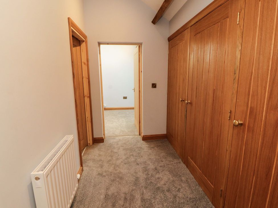 A hallway with wooden doors and a radiator at Dam House Barn Lancaster