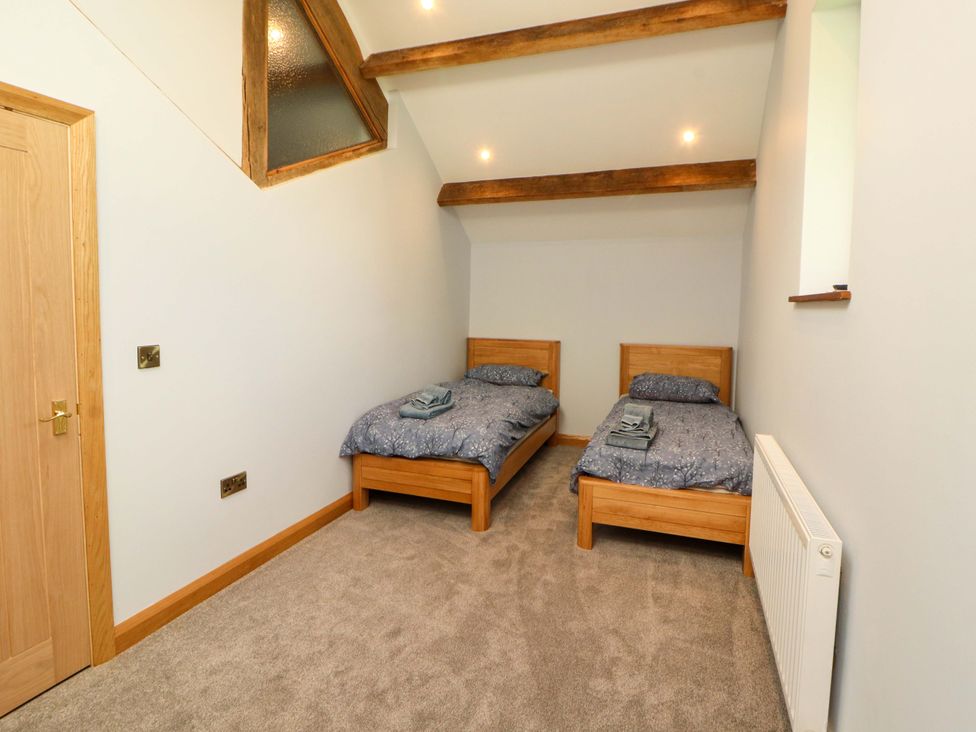 A bedroom with two beds and a radiator at Dam House Barn Lancaster
