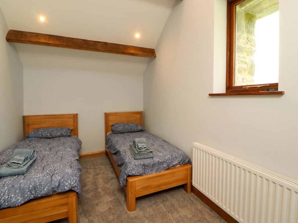 A bedroom with two single beds and a window at Dam House Barn in Lancaster