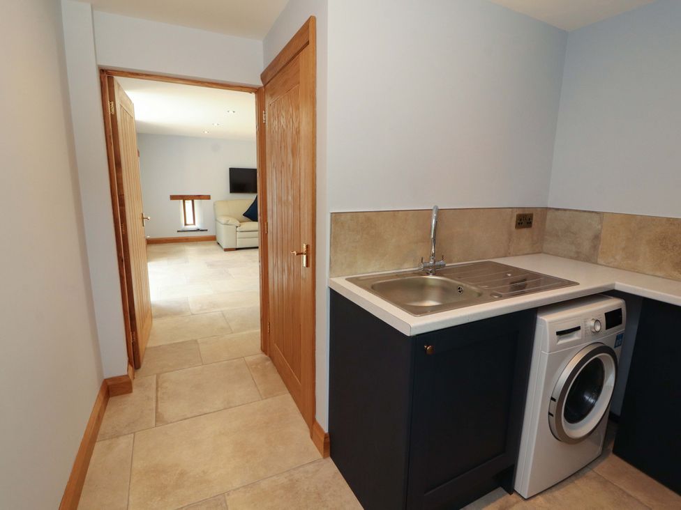 A utility room with a sink and washing machine at Dam House Barn in Lancaster