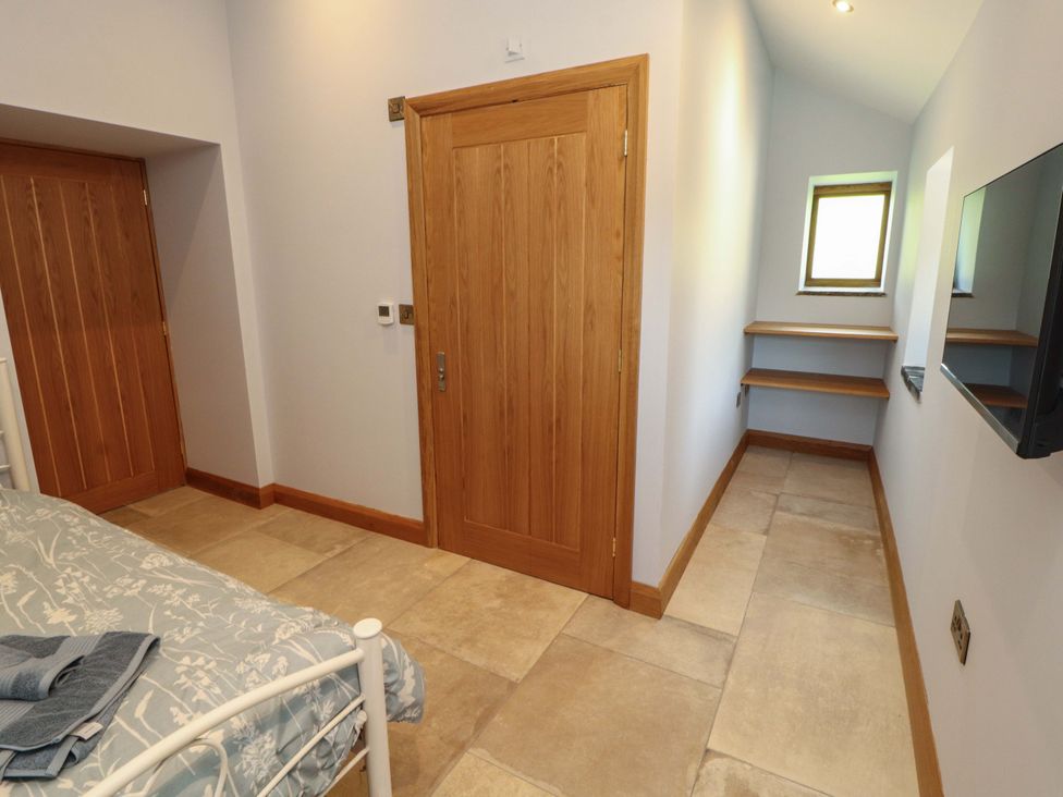 A bedroom with a bed and shelves at Dam House Barn in Lancaster