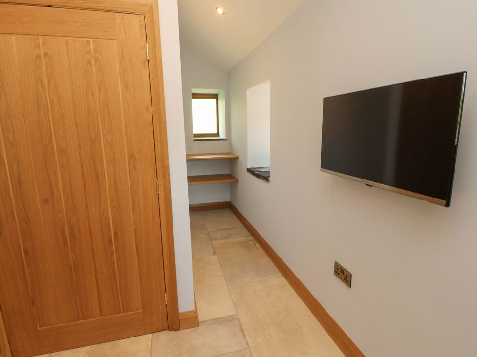 A room with a television and shelves at Dam House Barn Lancaster