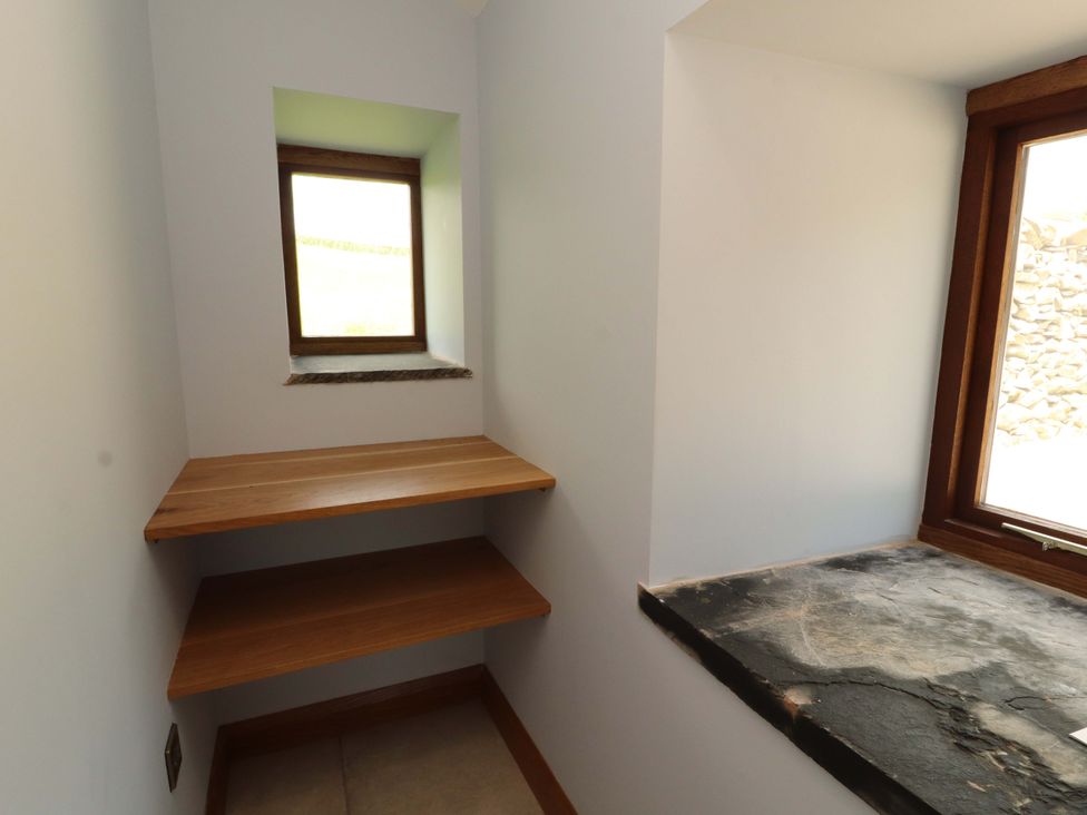 A storage room with wooden shelves and a slate countertop at Dam House Barn in Lancaster