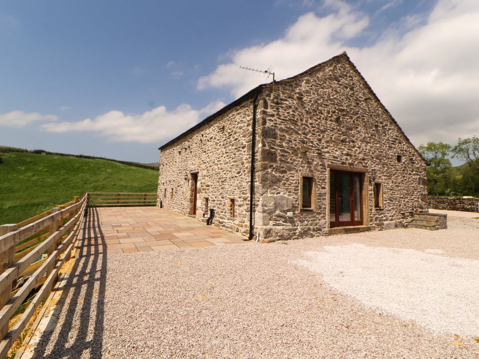 A stone building with double doors and patio at Dam House Barn in Lancaster