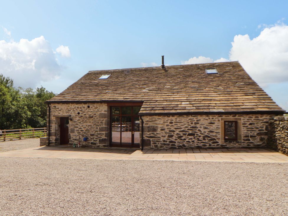 A barn with a stone wall and windows at Dam House Barn in Lancaster