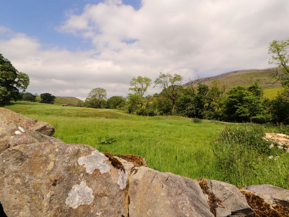 A landscape with a stone wall and grass fields at Dam House Barn in Lancaster