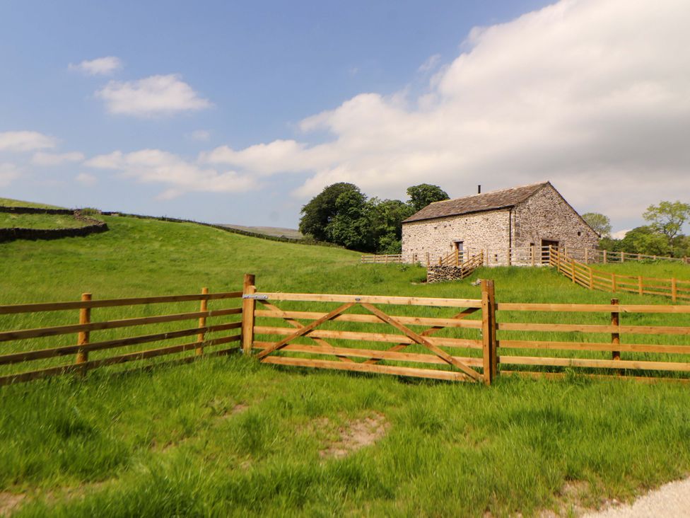 A barn surrounded by a fence and grass at Dam House Barn in Lancaster