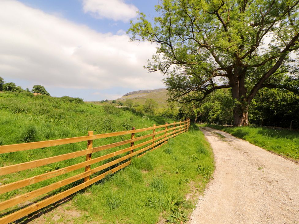 A dirt path with a fence and tree in a scenic outdoor area at Dam House Barn Lancaster