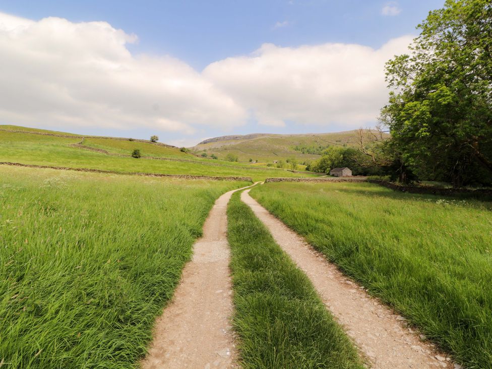 A path winding through grass and trees in a rural area at Dam House Barn Lancaster