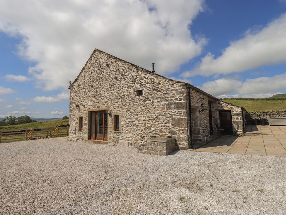 An outdoor view of a stone barn at Dam House Barn in Austwick