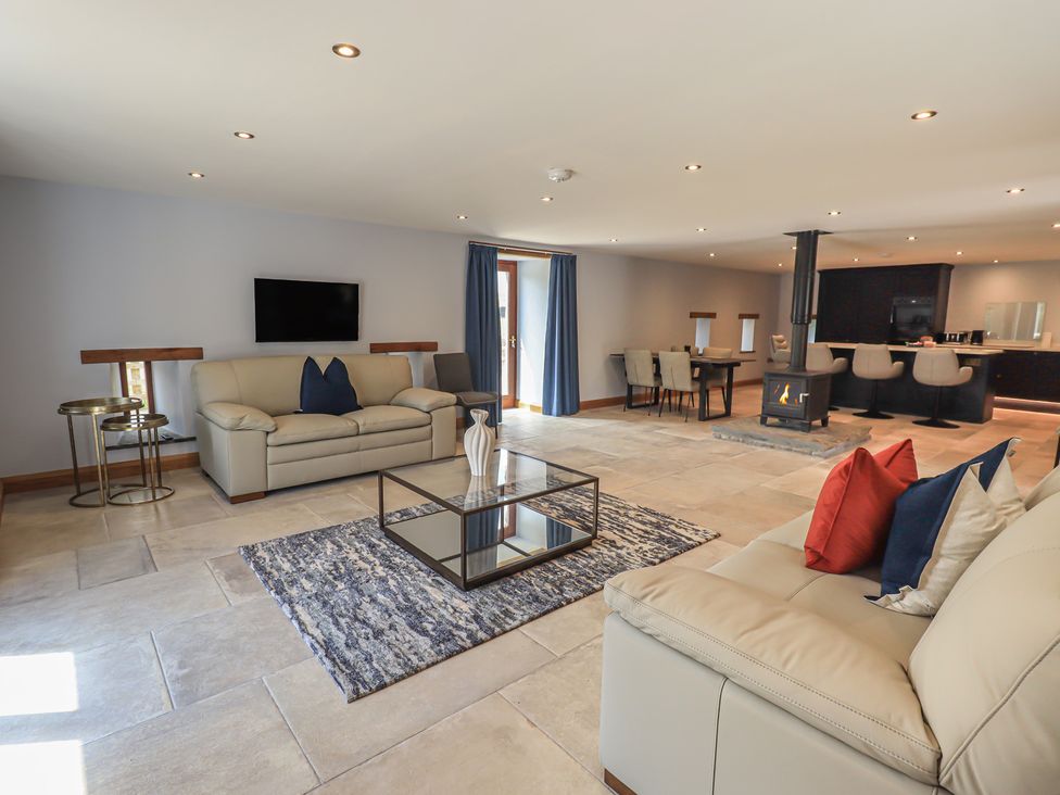 A living room with sofas and a fireplace at Dam House Barn in Austwick