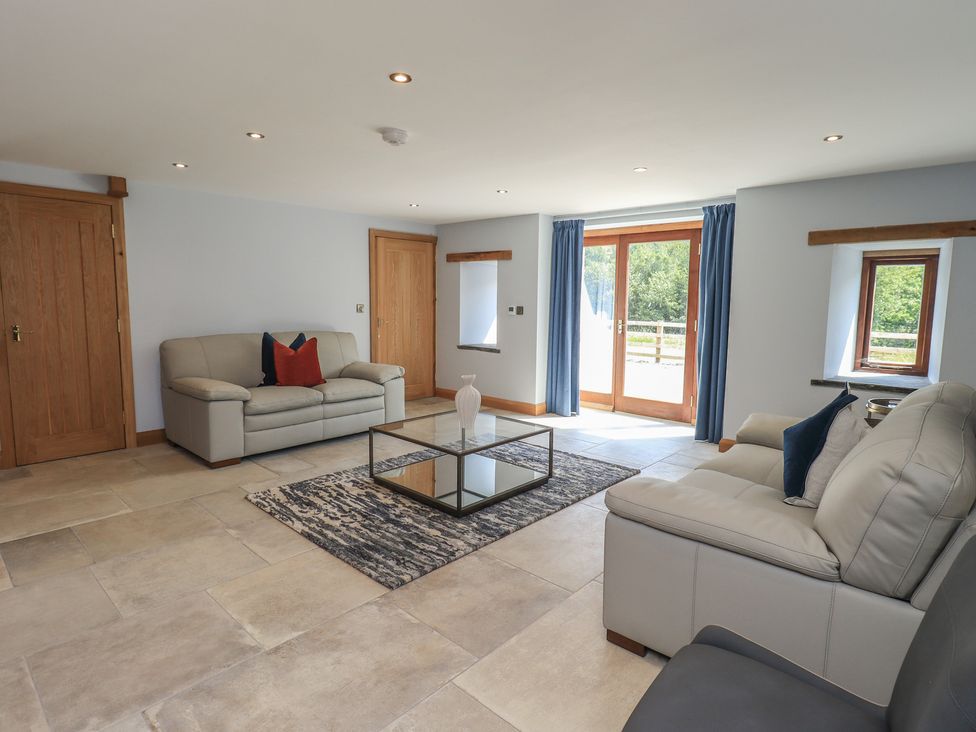 A living room with a sofa and table at Dam House Barn in Austwick