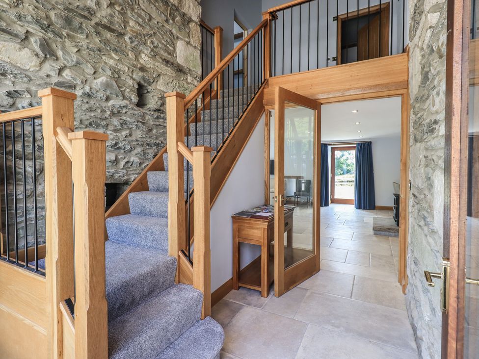 An entryway with a staircase and stone wall at Dam House Barn in Austwick