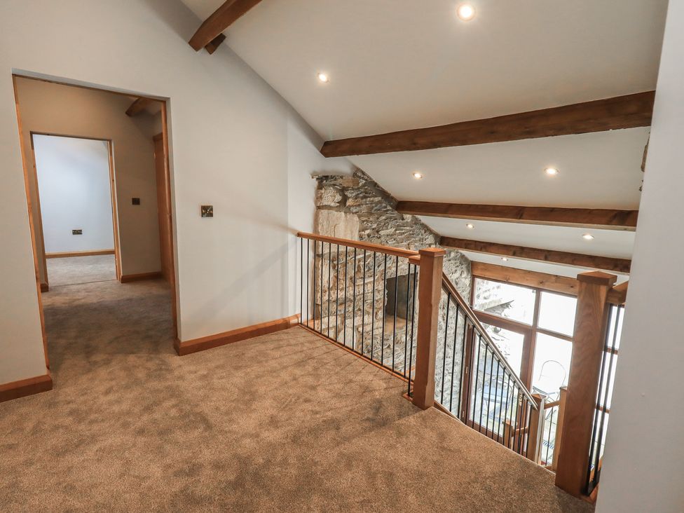 A hallway with a staircase and railing at Dam House Barn in Austwick