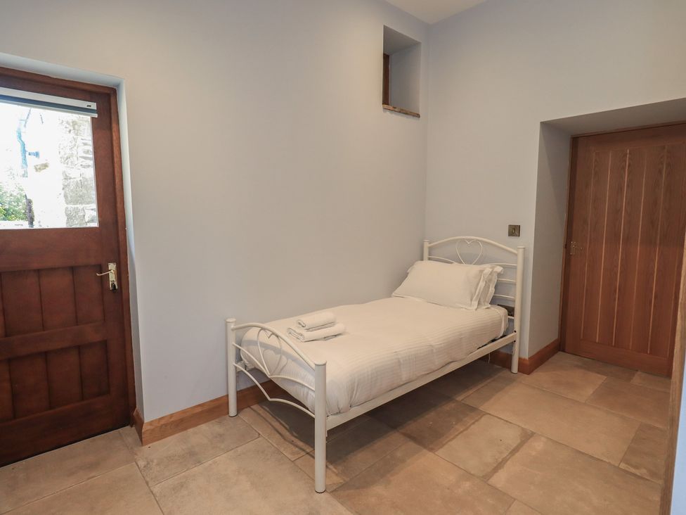 A bedroom with a bed and door at Dam House Barn Austwick