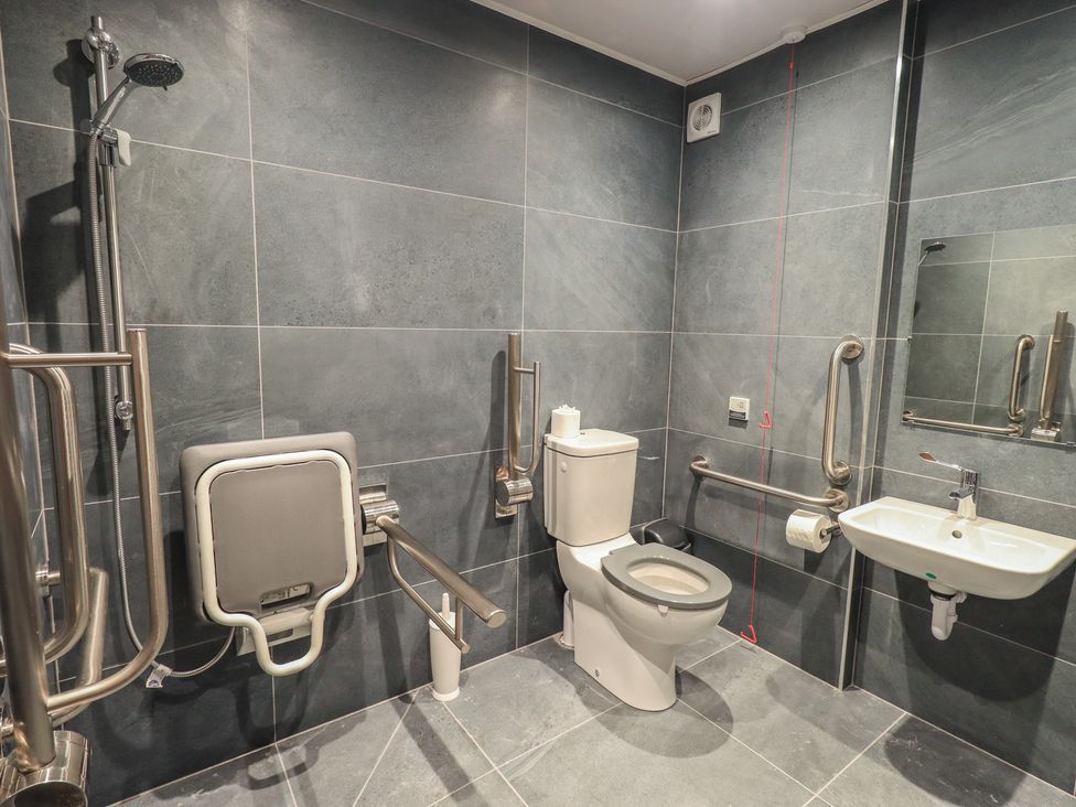 A bathroom with a shower, toilet, and sink at Dam House Barn in Austwick