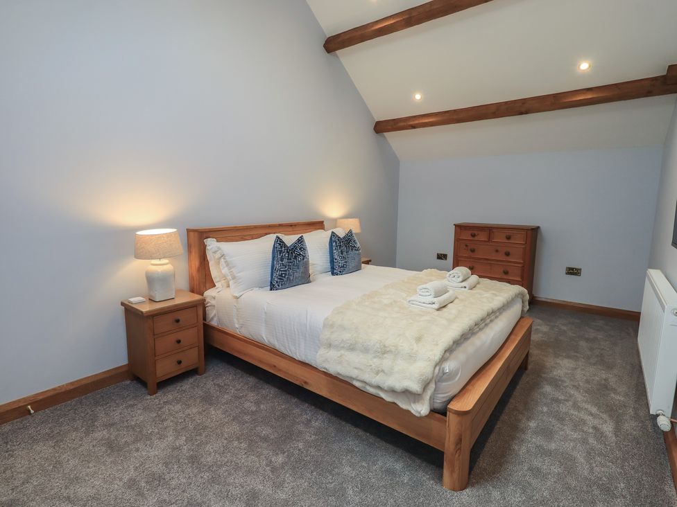A bedroom with a bed and bedside table at Dam House Barn in Austwick